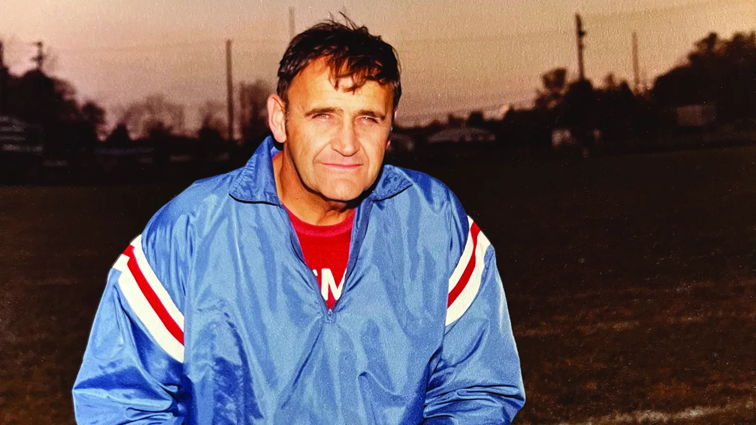 bob stuart wearing a light blue jacket and red t-shirt