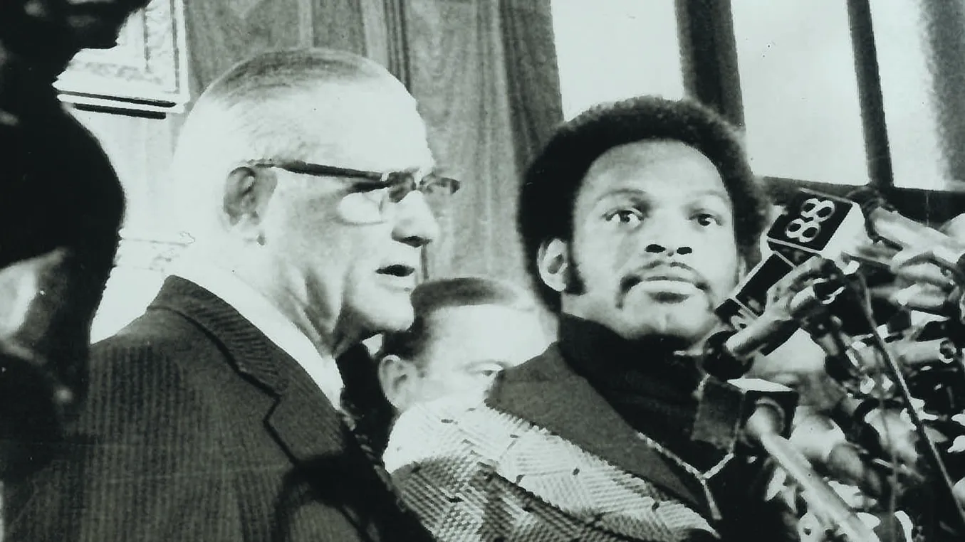 woody hayes and archie griffin stand behind dozens of microphones during Heisman trophy ceremony