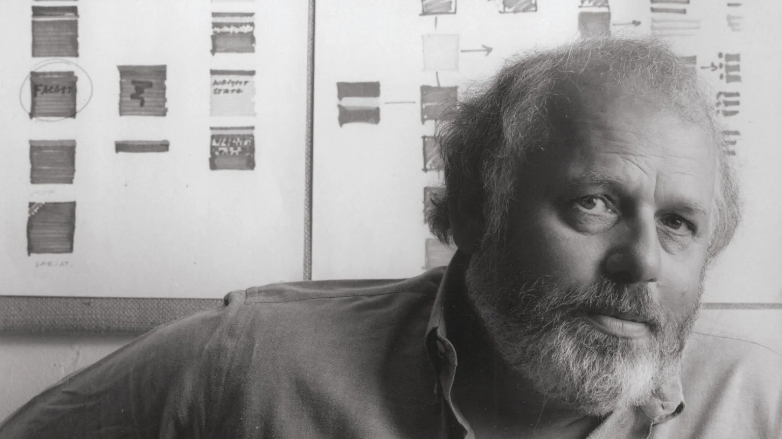 Peter Megert is shown in a portrait. He’s a white man with beard and wispy gray hair that hangs past his ears. He looks directly into the camera, appearing both serious and intellectual, but not in an unfriendly way.