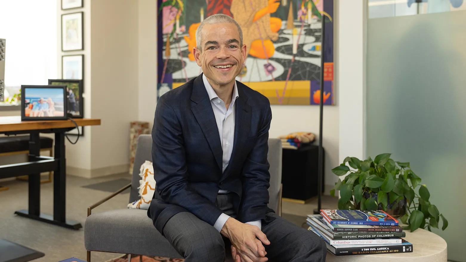 Matt Scantland smiles as he poses for a portrait in his office. He's a thin, white, middle age man with close cropped hair wearing a sport coat. His smile is genuine.