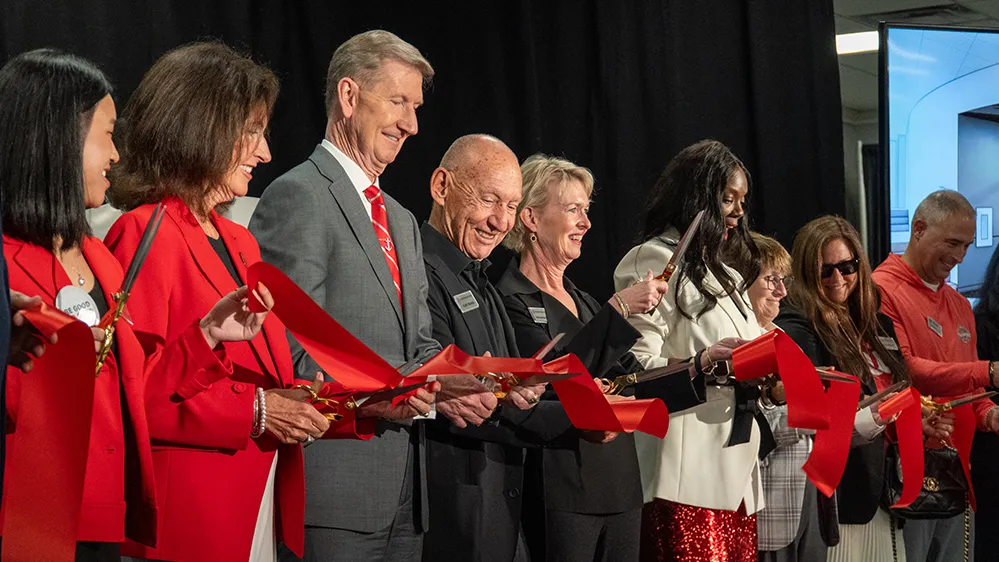 Veronica Brady and Keith Monda are joined by university leaders--the president and his wife and the vice president of student life--to cut the big ribbon that officially opens the student resource center