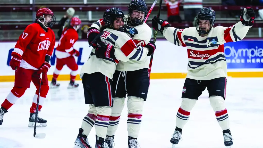 Three Ohio State women's hockey players celebrate winning a game while on the ice
