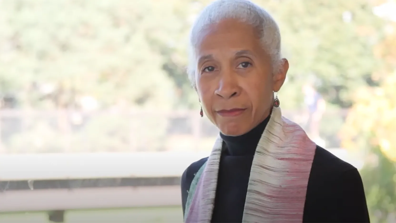 Diane, with her trademark hair-pulled-back and dangly earrings, looks directly into the camera with a thoughtful but serious expression.