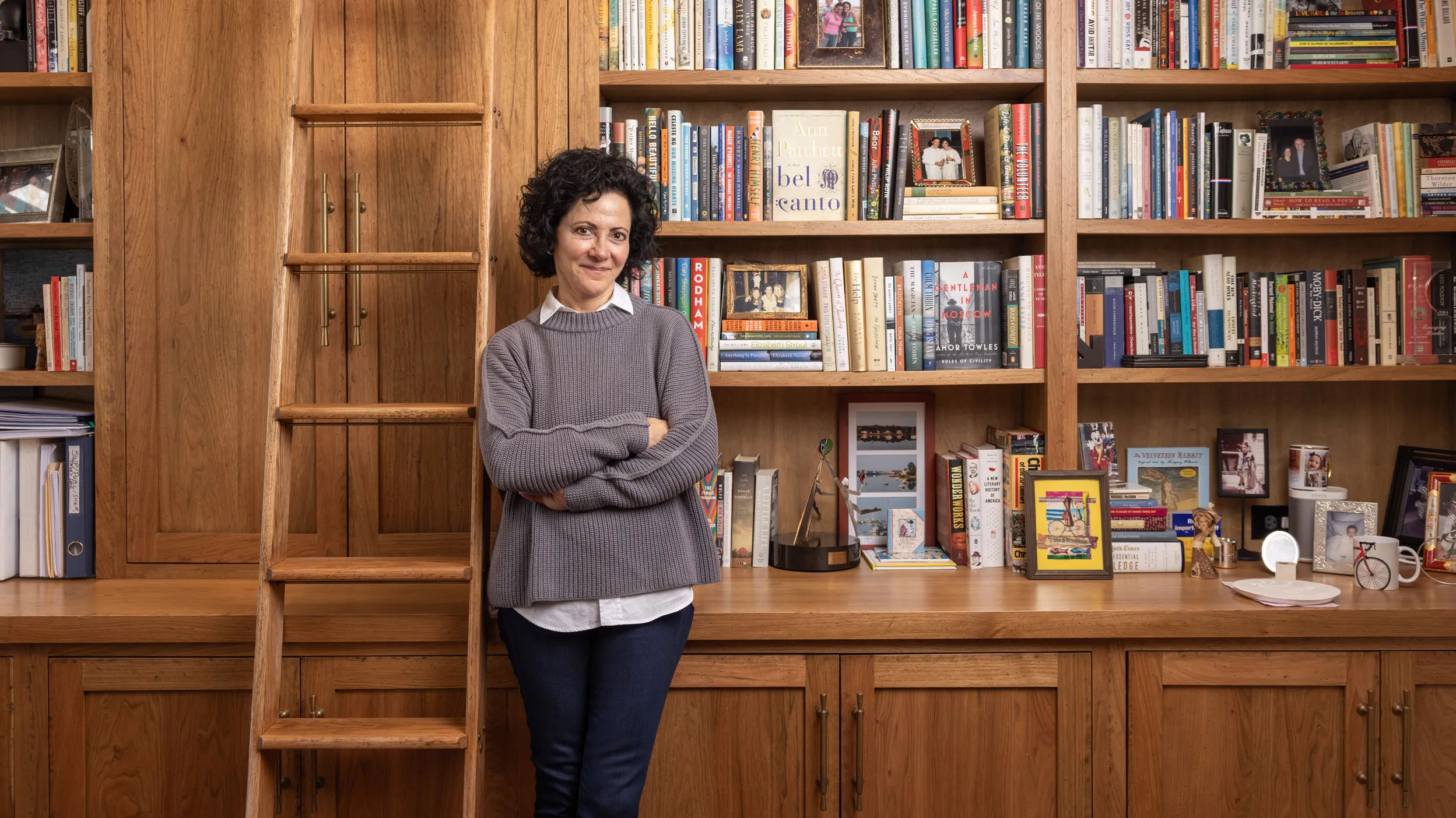 Linda Kass smiles as she leans against shelving packed full of books in her home study. It has a woody, homey feel--classic yet elegant and casual at the same time-just like Linda herself. She's a small-framed woman with dark curly hair and a mischievous expression.