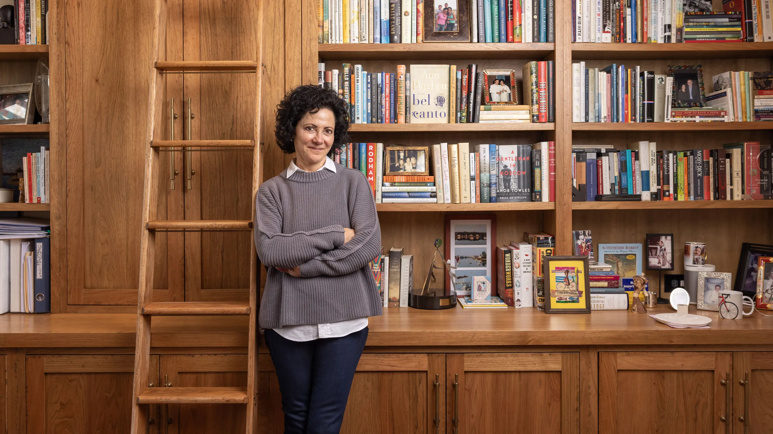 Linda Kass smiles as she leans against shelving packed full of books in her home study. It has a woody, homey feel--classic yet elegant and casual at the same time-just like Linda herself. She's a small-framed woman with dark curly hair and a mischievous expression.