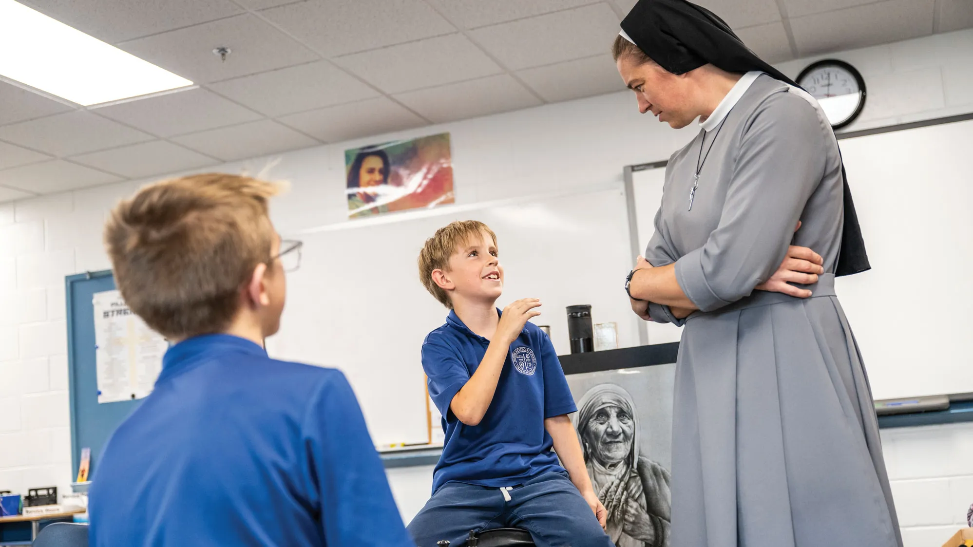 Sister listens intently as a boy tells her a story. Sitting across from him is the boy playing against him in chess.