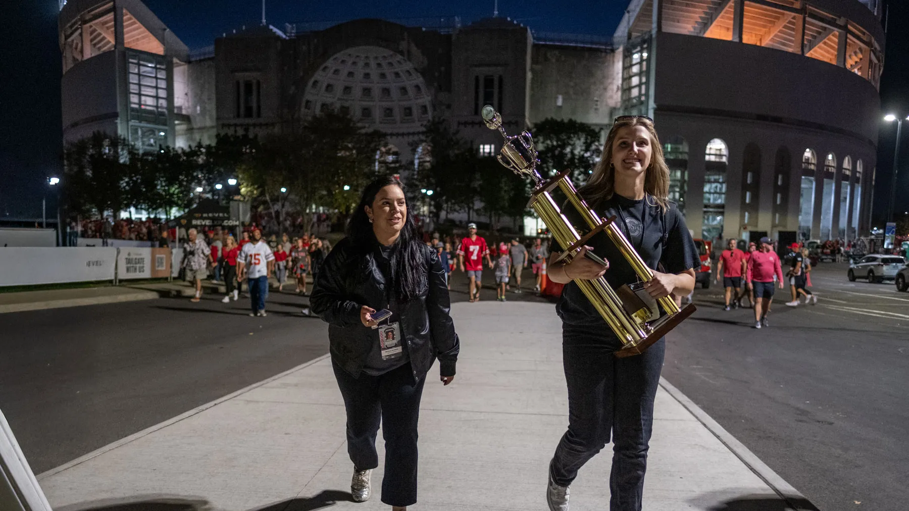 Melissa walks with an assistant coach as they head away from Ohio Stadium in the dark.