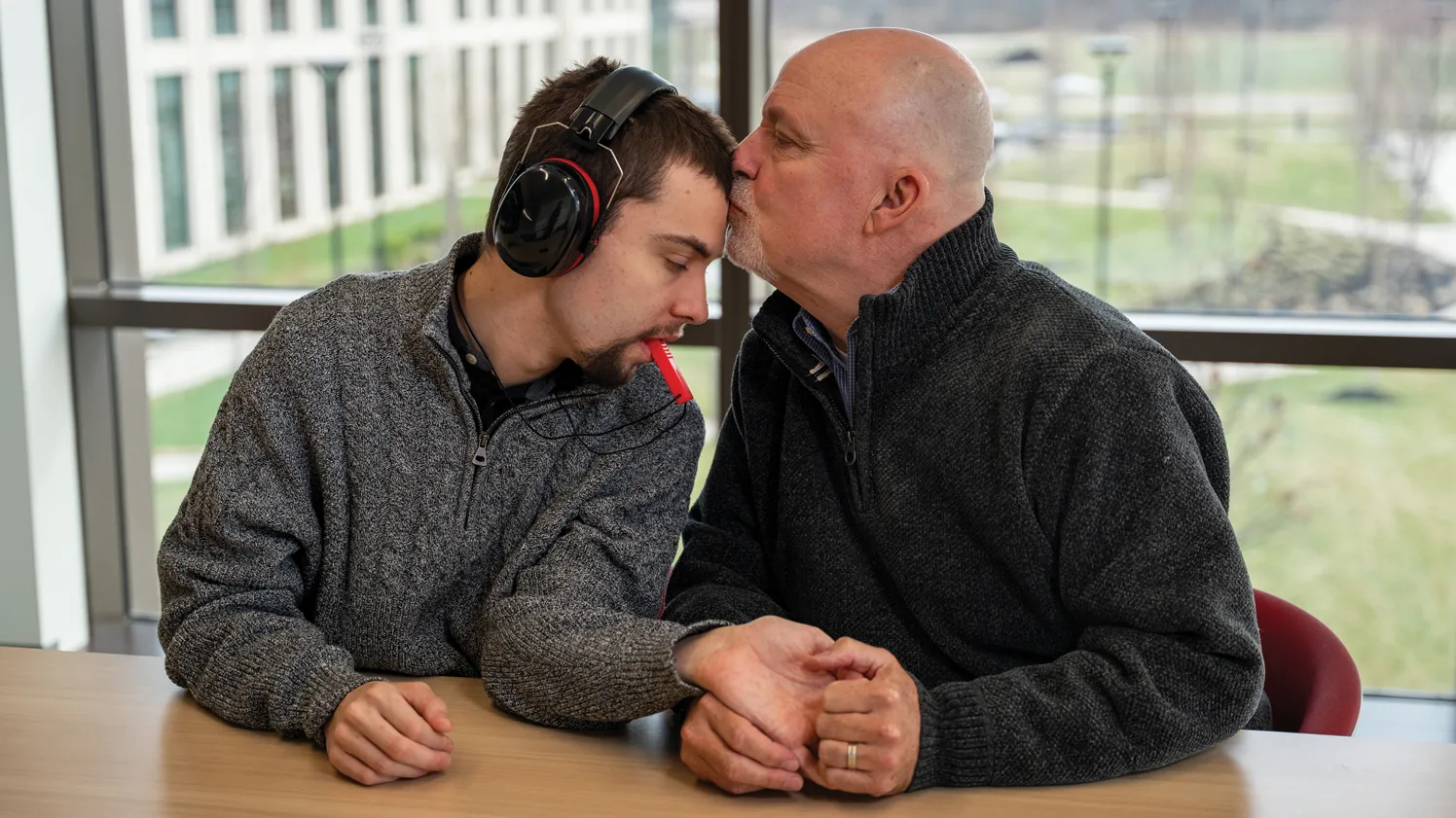A father kisses his son on the forehead.