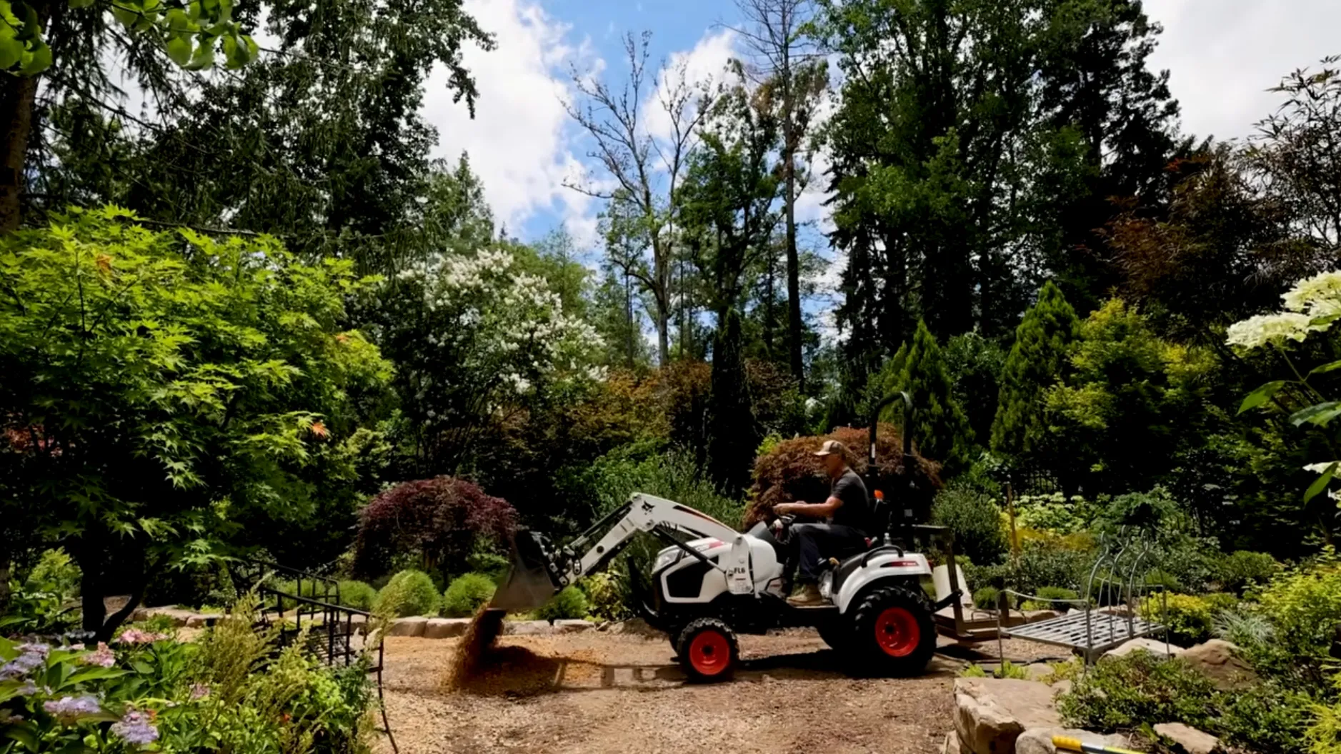 Hutchison drives a tractor along a trail in his garden