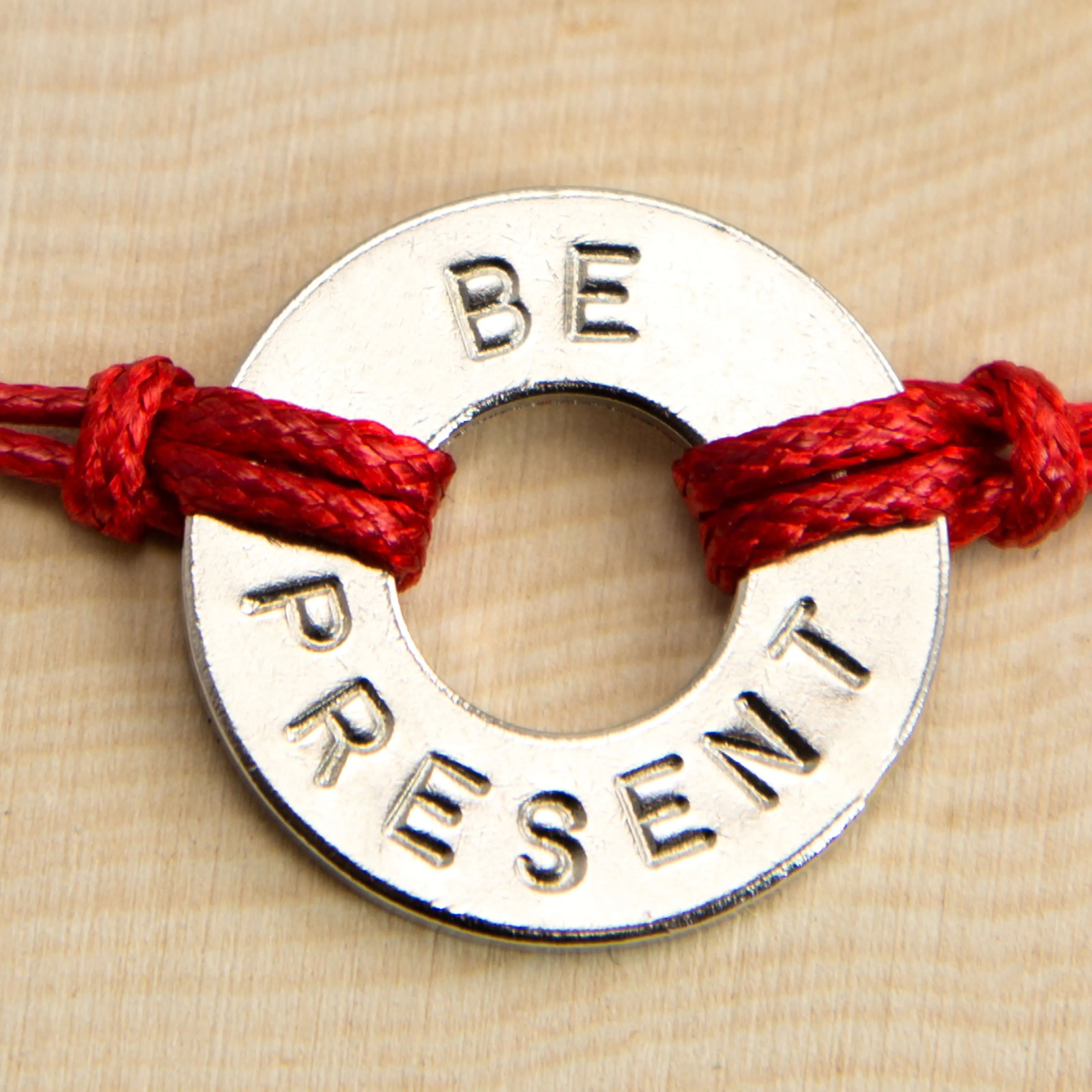 Washer with word "BE PRESENT" imprinted with red rope