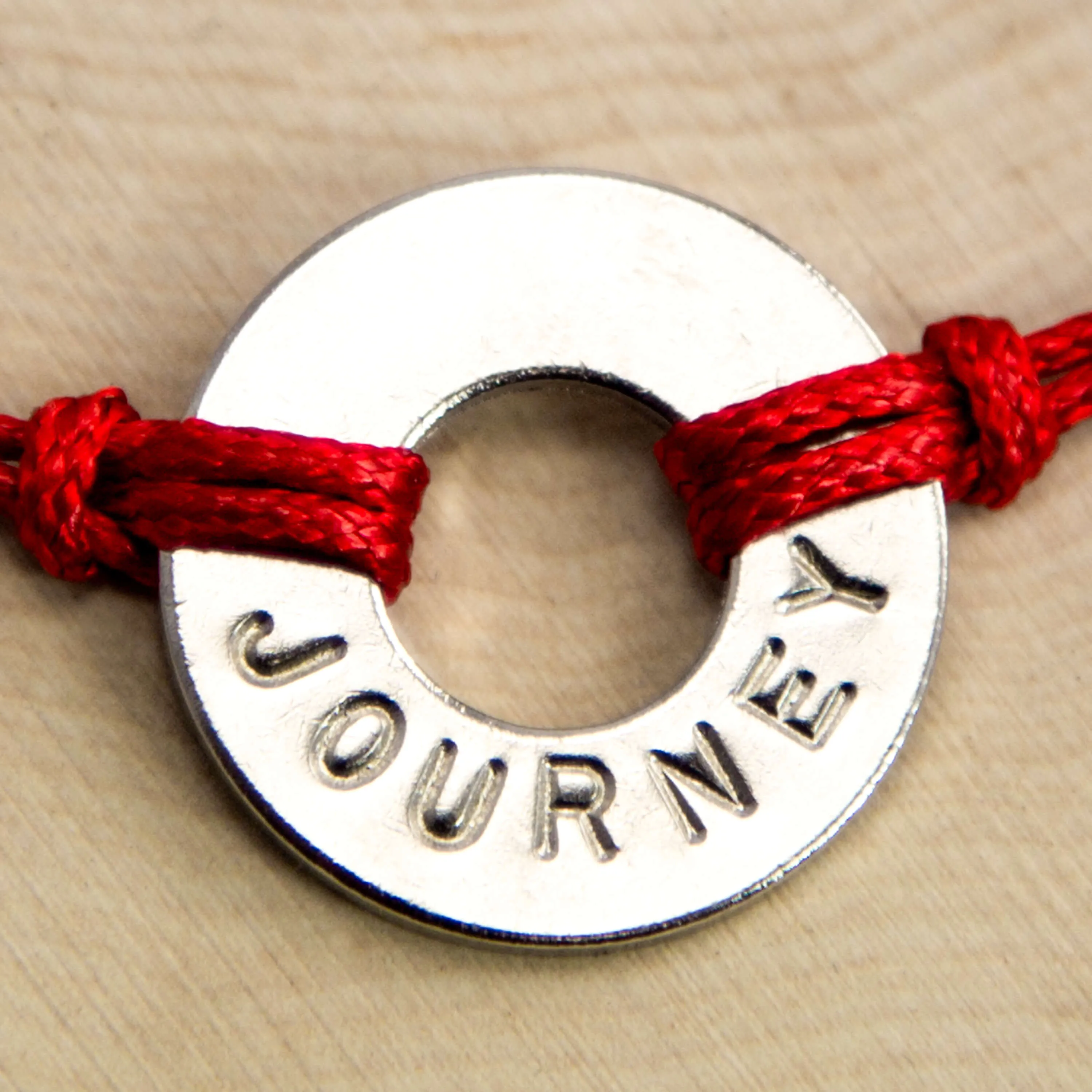 Washer with word "JOURNEY" imprinted with red rope