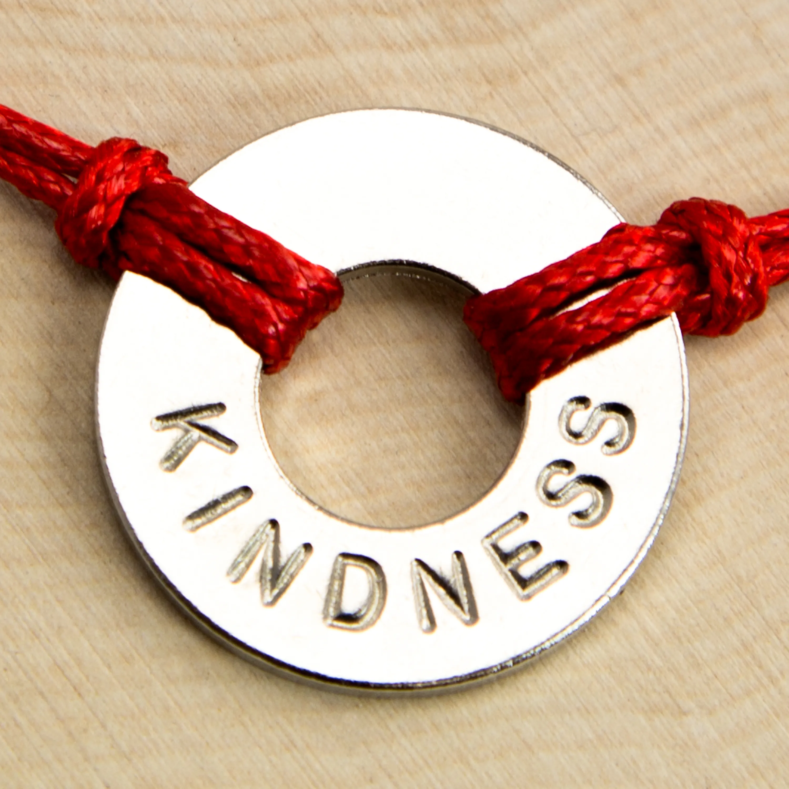 Washer with word "KINDNESS" imprinted with red rope