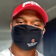 Black man wearing a read hat and black cloth facemask