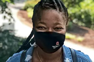 Black woman with braids wearing a black cloth facemask