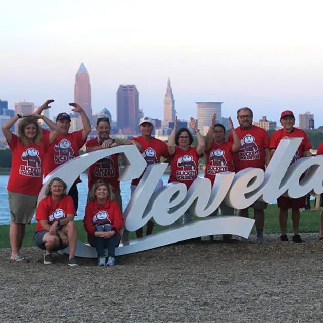 students wearing ohio state shirts surround the Cleveland sign at Edgewater park