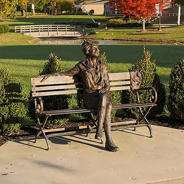 A lifesize sculpture of Amelia Earhart sits on a bench
