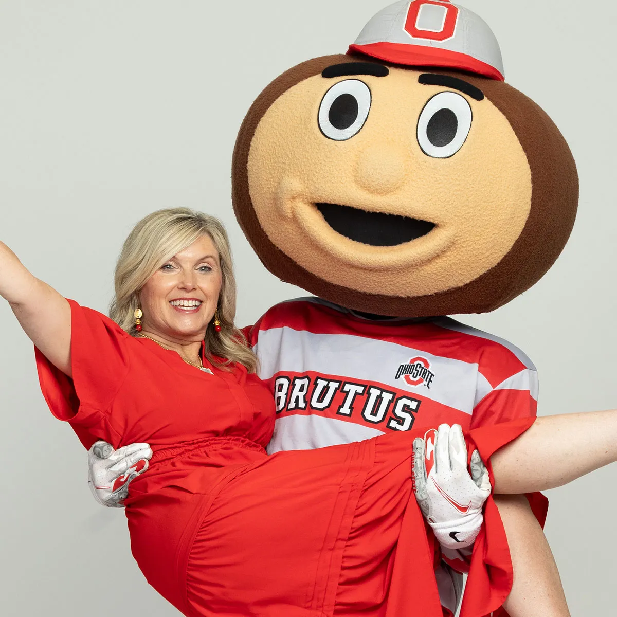  Brutus Buckeye poses with a smiling blond lady, who he's holding a cradle pose