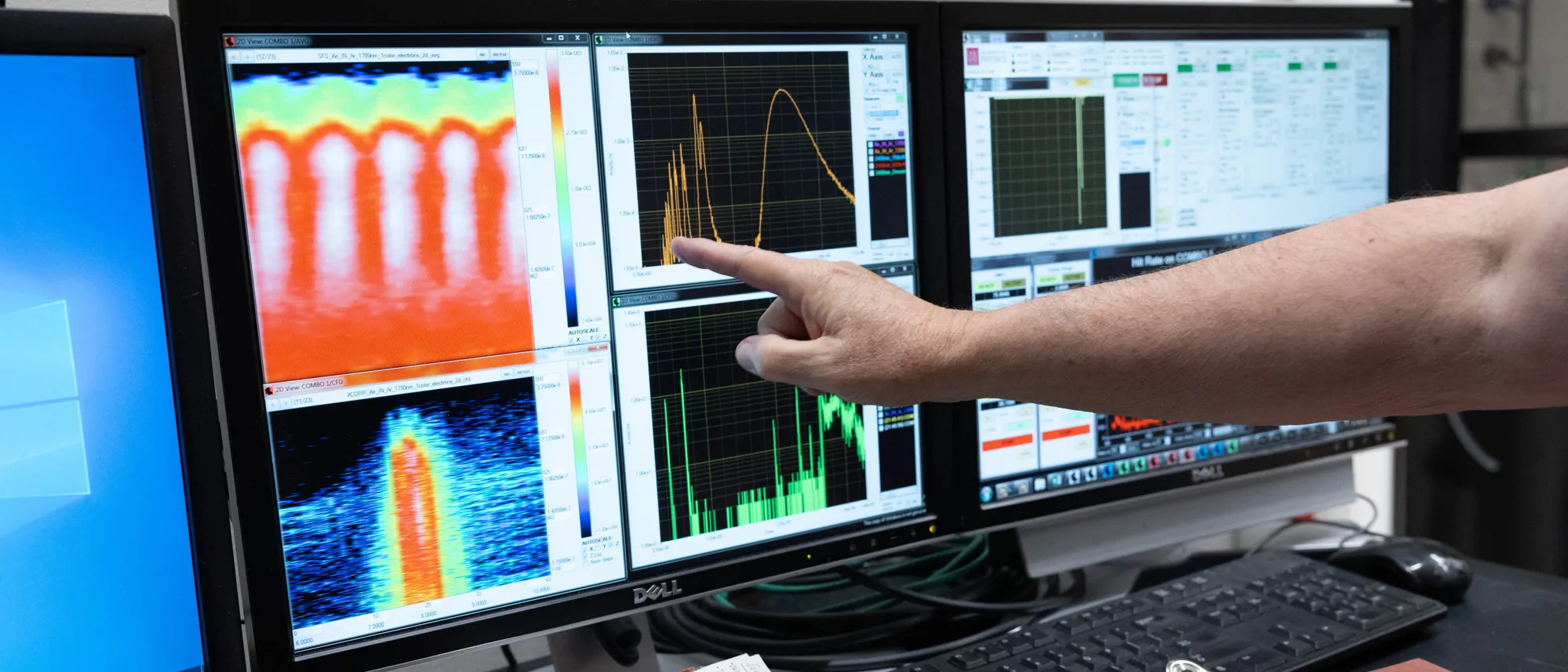 Three computer screens illustrate the results of the quantum selector experiments--specifically, how electrons reacted to light pulses. The screens show colorful line graphs and spectral analyses.