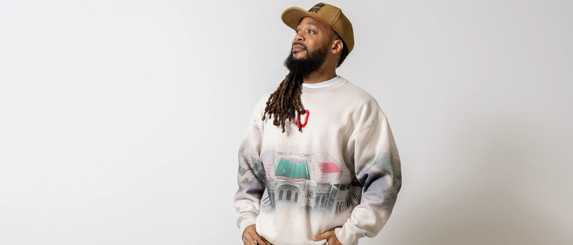 Banner poses in his sweatshirt, hat and pants looking off into the distance.
