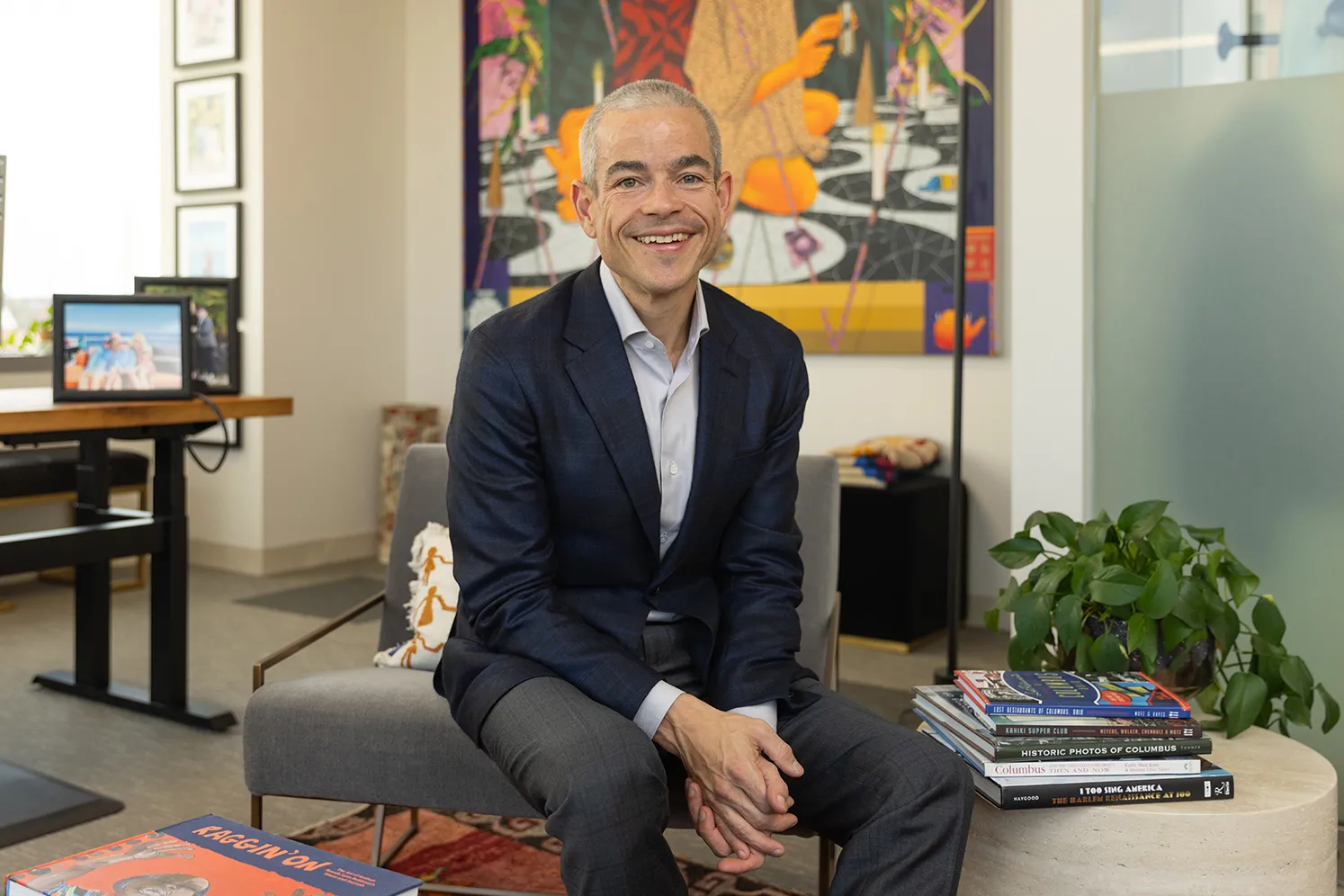 Matt Scantland smiles as he poses for a portrait in his office. He's a thin, white, middle age man with close cropped hair wearing a sport coat. His smile is genuine.