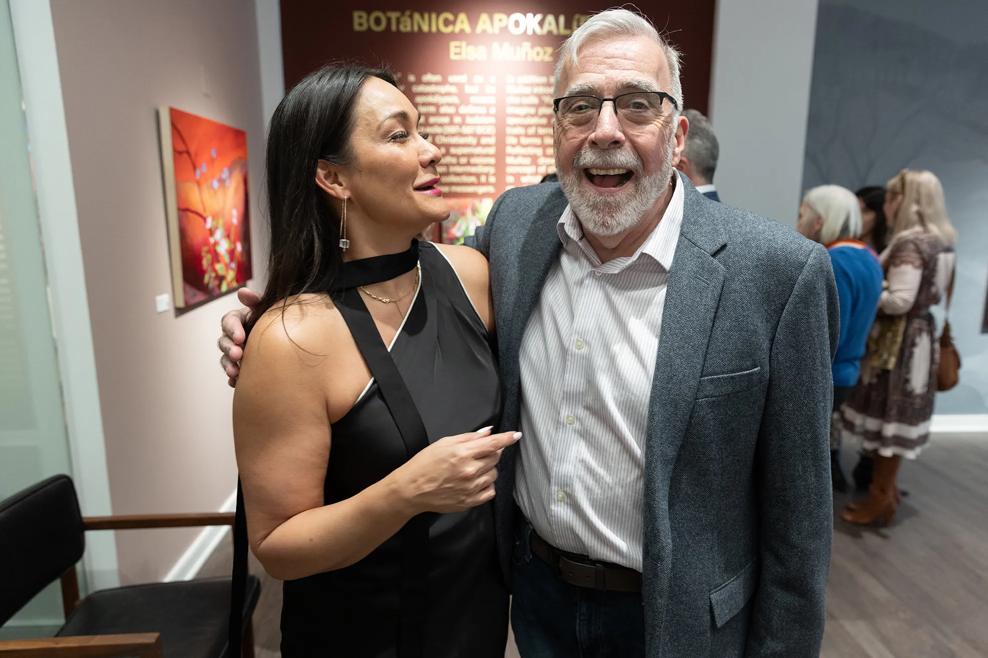Michelle Brandt and Duff Lindsay laugh as they stand with arms around each other. Their amusement feels genuine and comfortable.