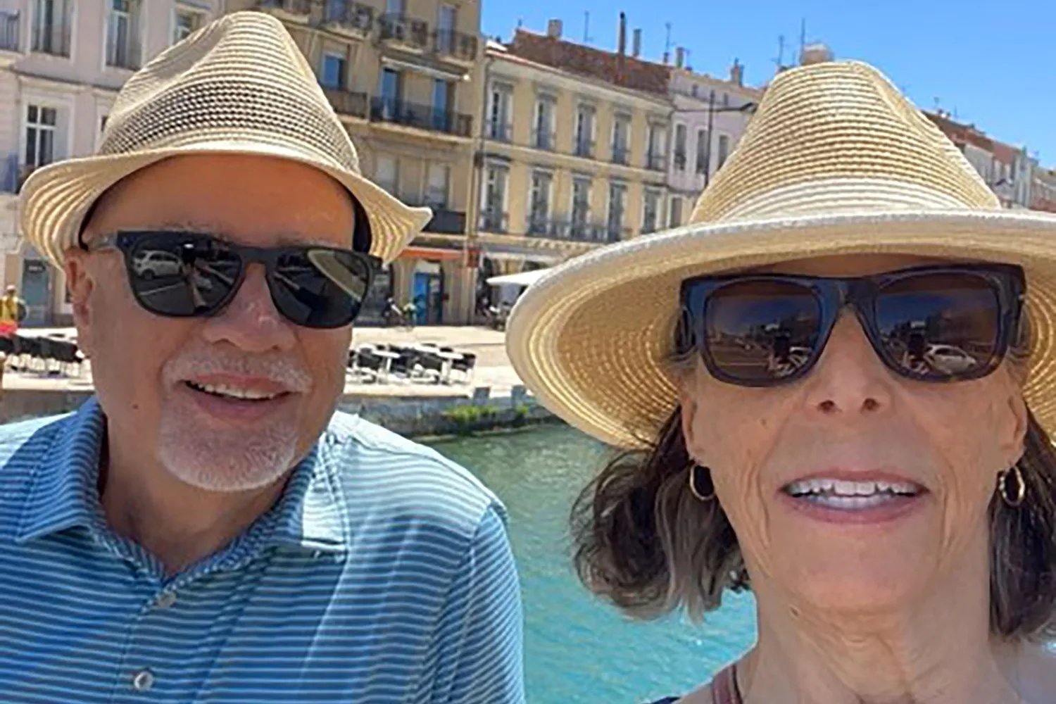 The couple grin and wear sunglasses on a European vacation.