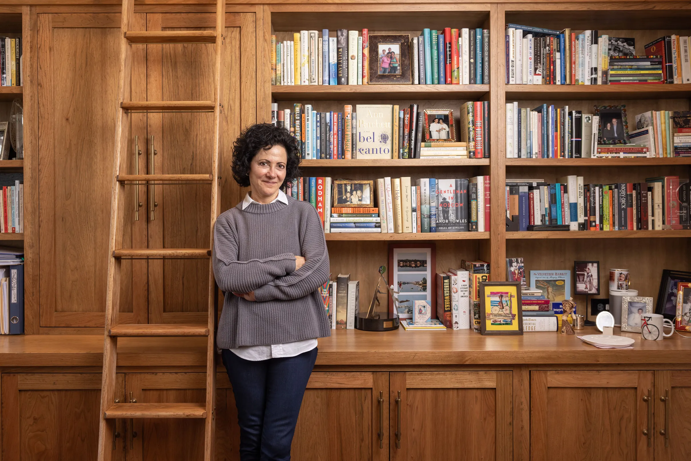 Linda Kass smiles as she leans against shelving packed full of books in her home study. It has a woody, homey feel--classic yet elegant and casual at the same time-just like Linda herself. She's a small-framed woman with dark curly hair and a mischievous expression.