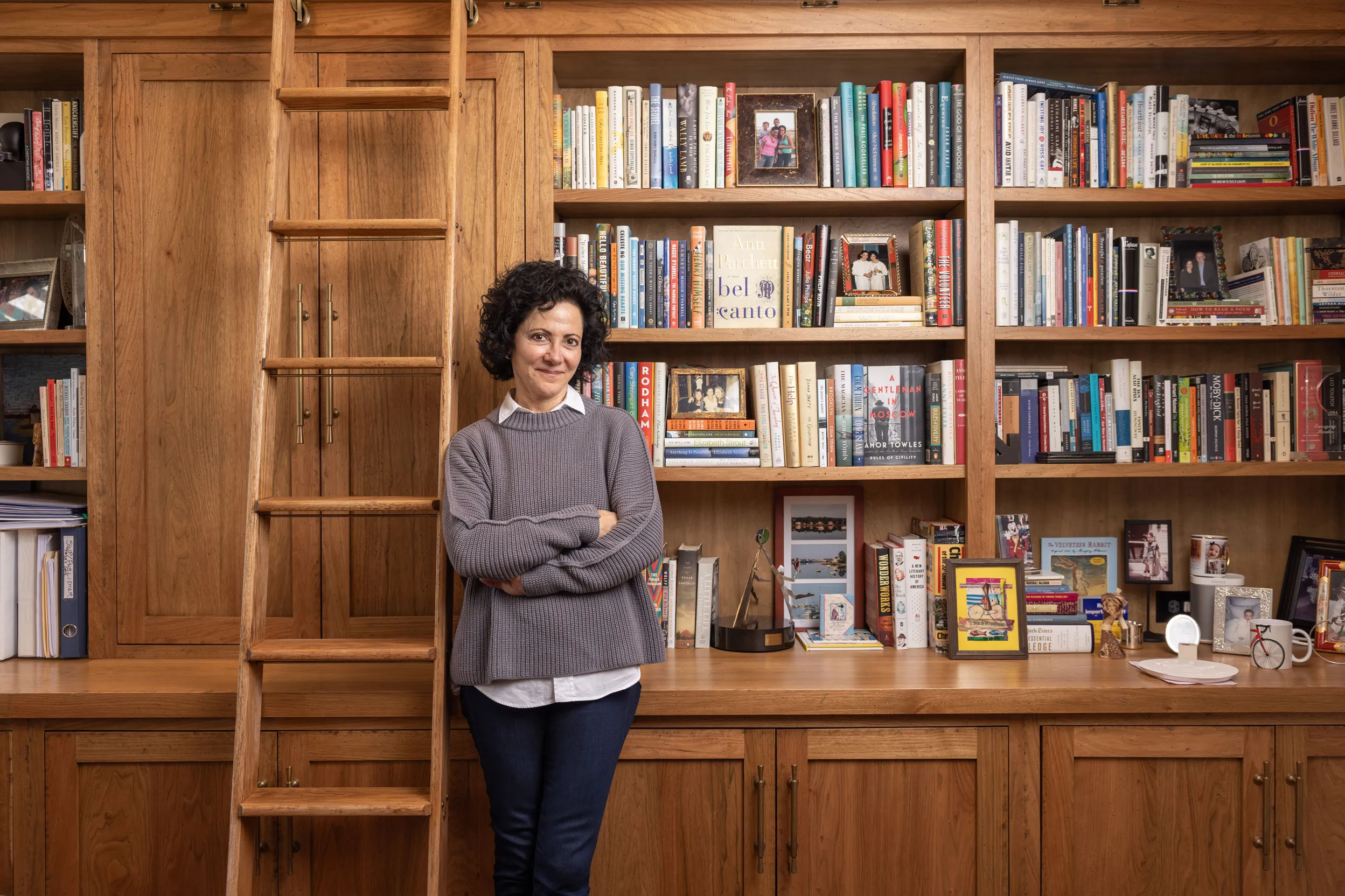 Linda Kass smiles as she leans against shelving packed full of books in her home study. It has a woody, homey feel--classic yet elegant and casual at the same time-just like Linda herself. She's a small-framed woman with dark curly hair and a mischievous expression.