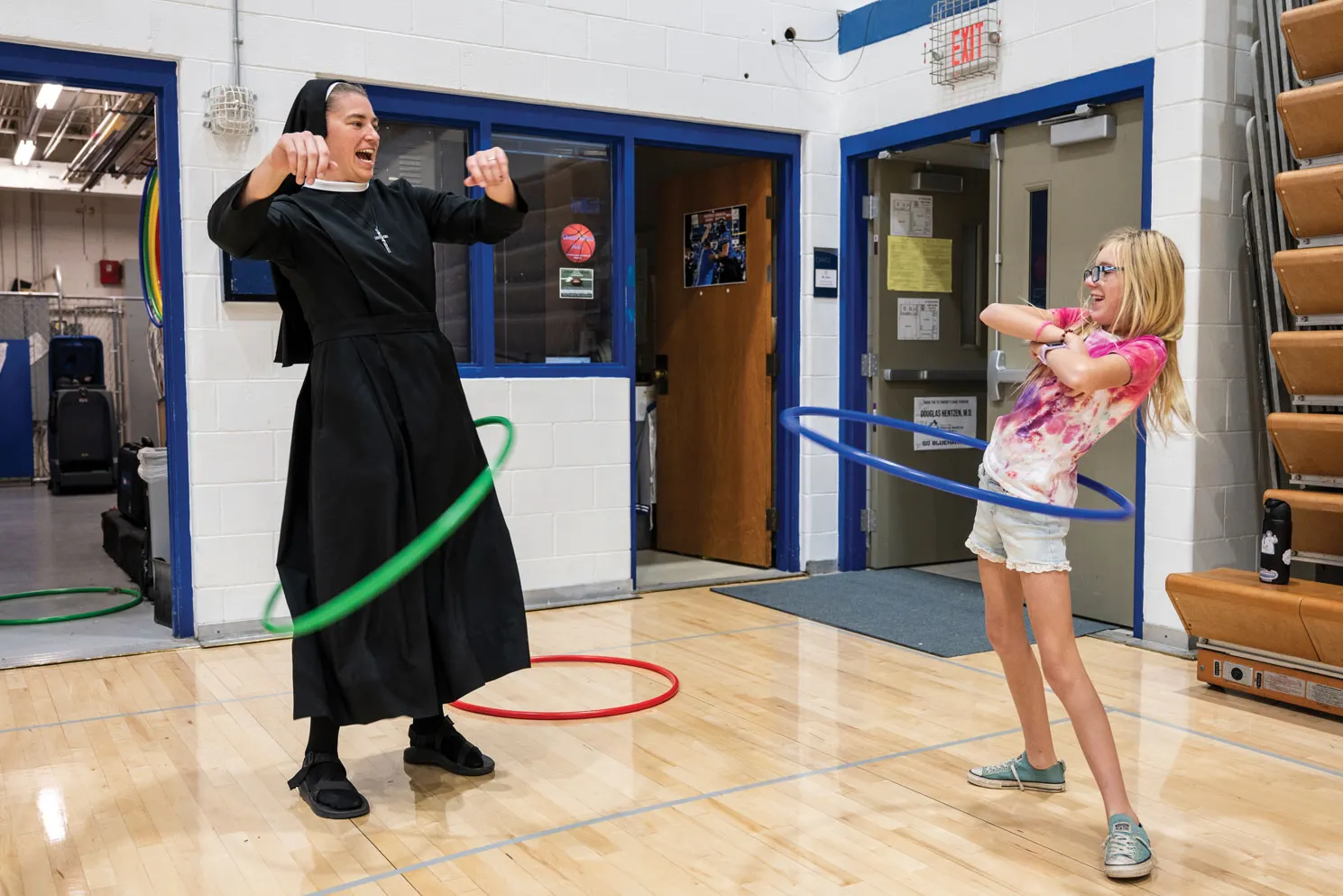 Sister hula hoops with a niece. They're both grinning.