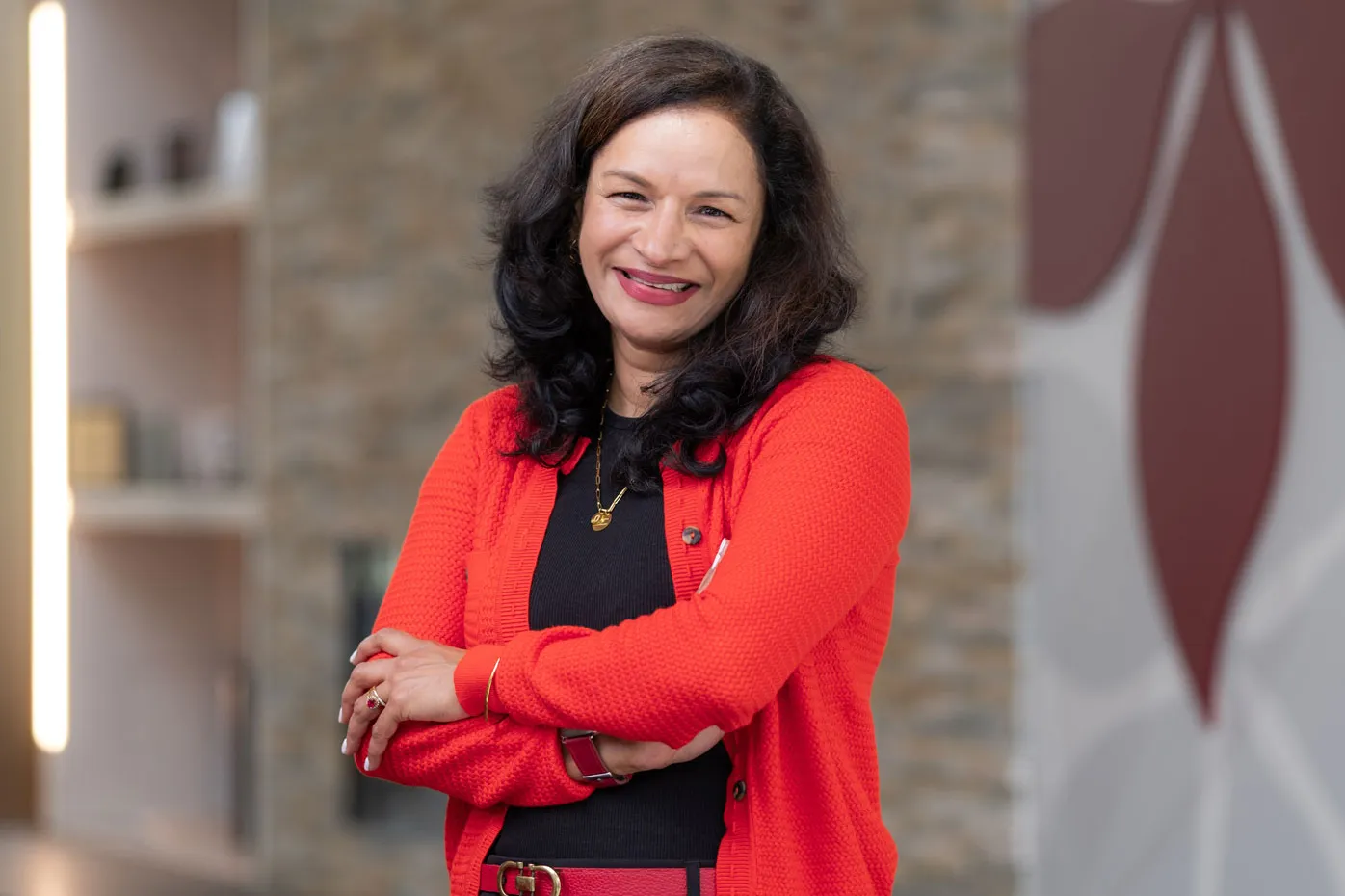 Lalita Kaligotla smiles as she poses for a photo inside an Ohio State building. She has long hair and wears a scarlet cardigan and belt over a dark T-shirt and dress pants. She comes across as both stylish and friendly, like someone you'd want to spend time talking with.