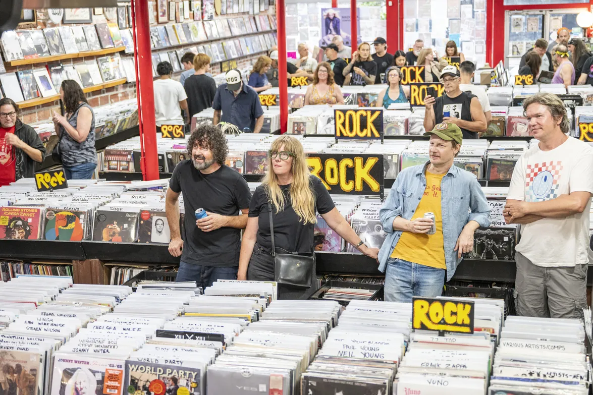 Patrons watch the band play while standing among the tables full of record bins
