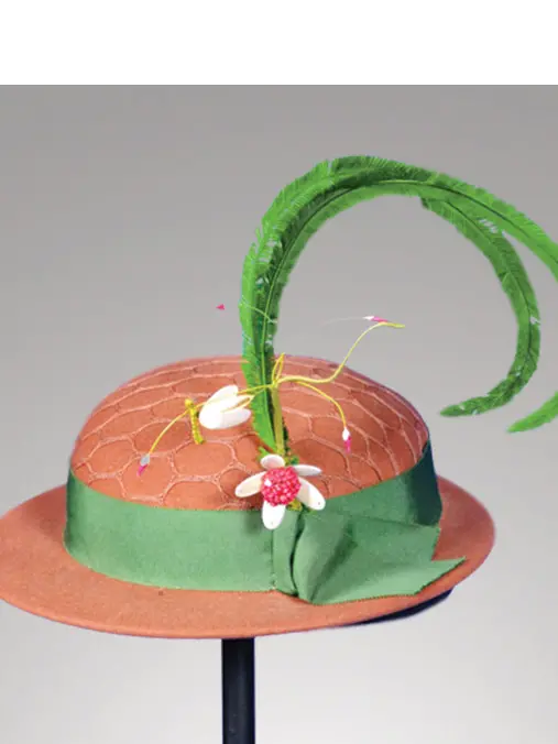 A light brown hat with a large green feather and ribbon around the brim