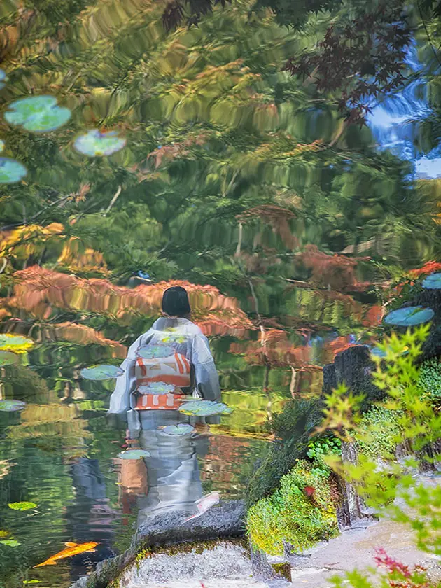 reflection of a woman standing by water in a garden