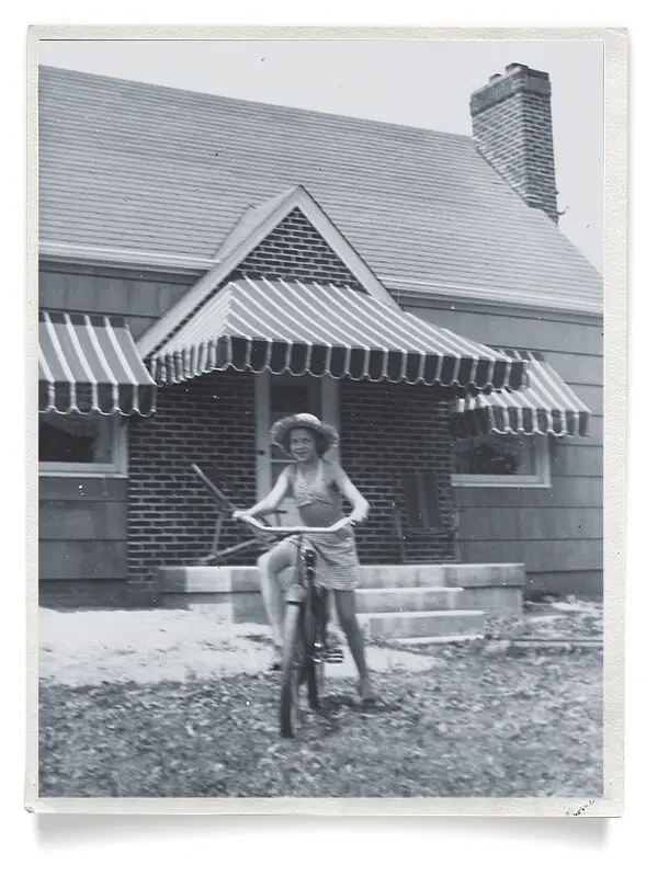 girl riding bike in front of home