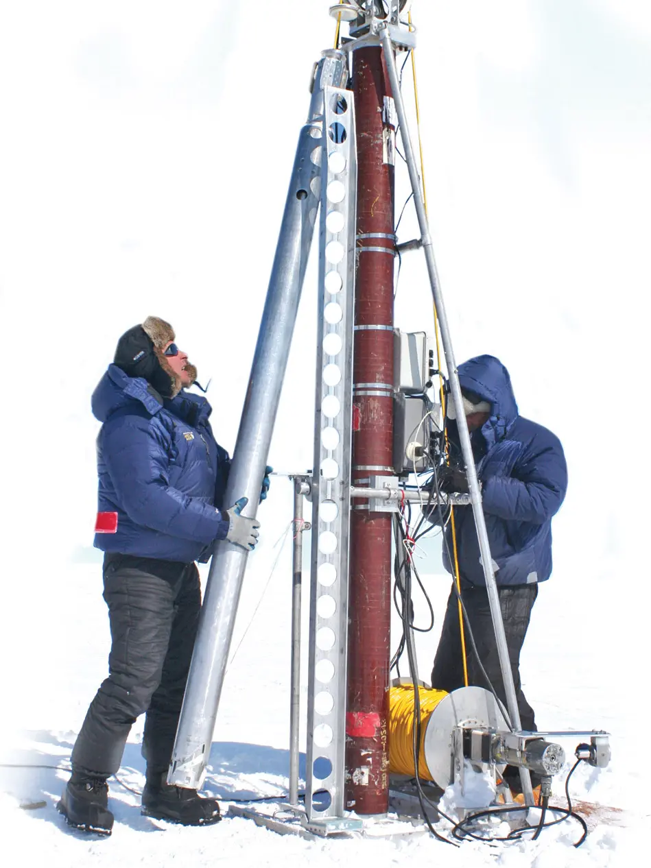 two people working on ice core drill