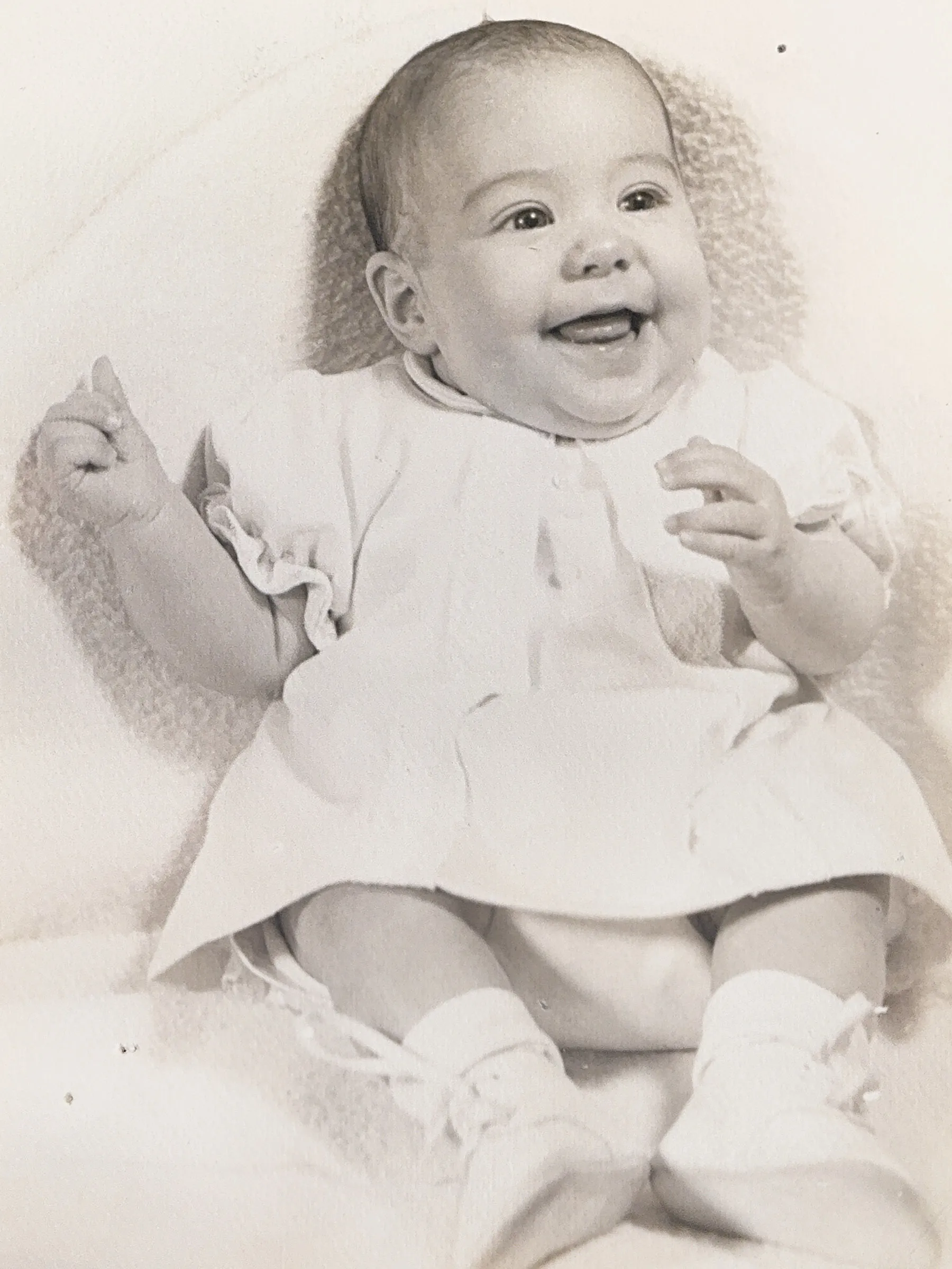 A baby photo show a super-cute Molly Ranz Calhoun with an open-mouthed smile. She's less than 1 year old here.
