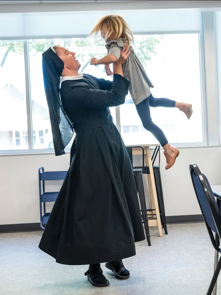 Sister picks up a young niece and swings her around