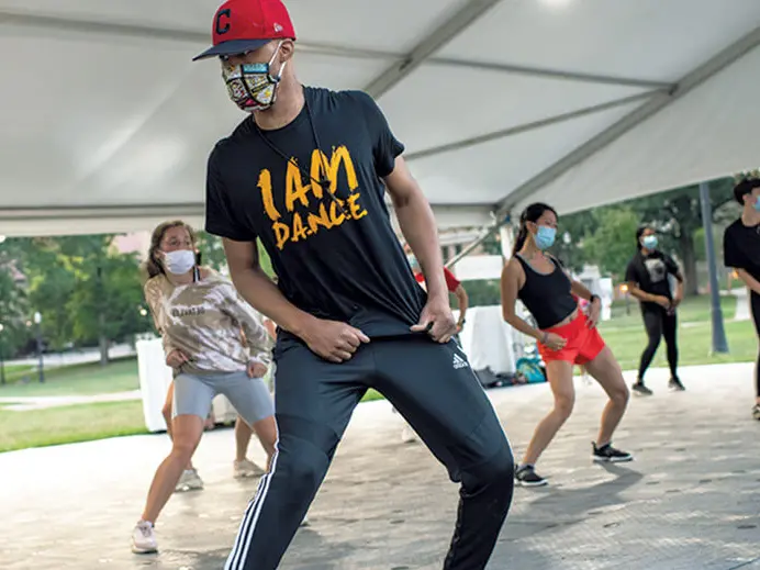 a group dance class outside under a tent