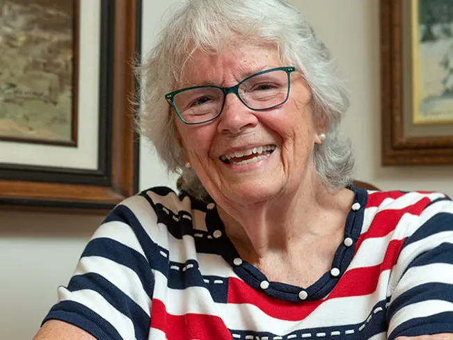 old lady sitting in chair smiling