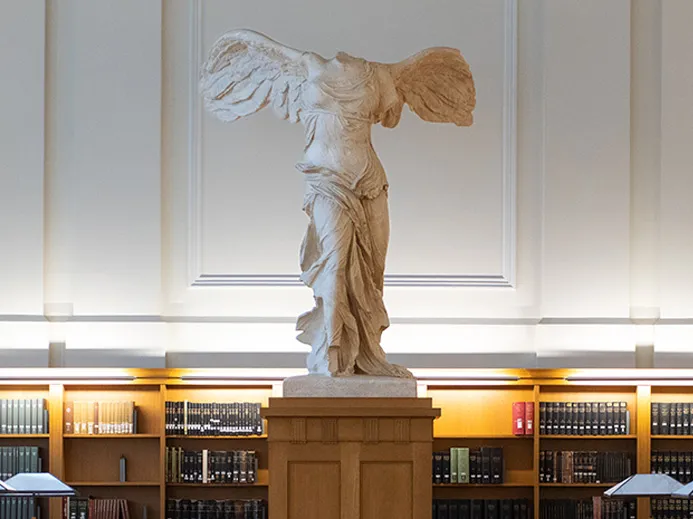 the statue Nike of Samothrace. a winged woman with flowing robes covering her body. the statues head and arms have been broken off