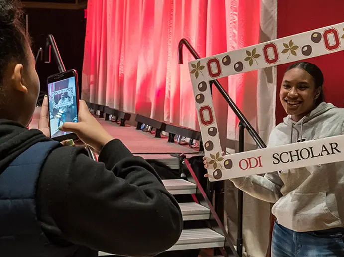 girl takes photo of another girl holding a picture frame