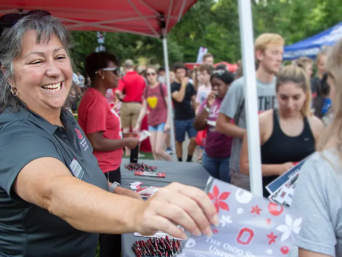 Molly Ranz Calhoun handing out Ohio State materials to students at a booth