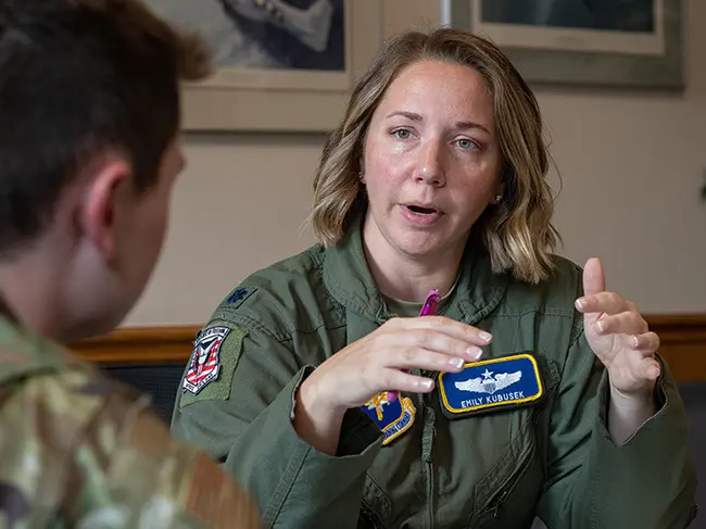 female talking to male on the left and two headshots of male soldiers on the right