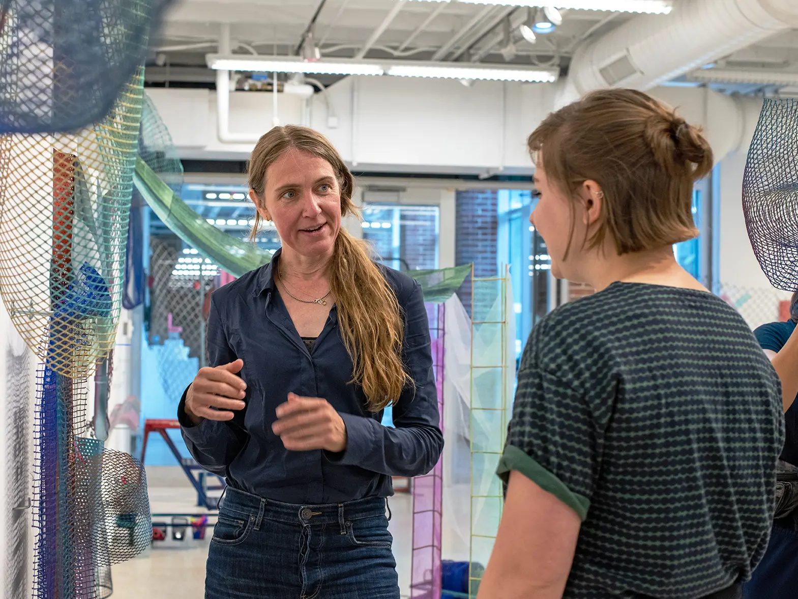 Merijn van der Heijden talks with student at art exhibit