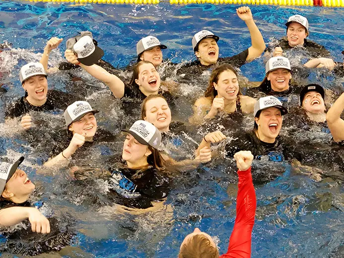 OSU women&#039;s swimming team celebrating in a pool