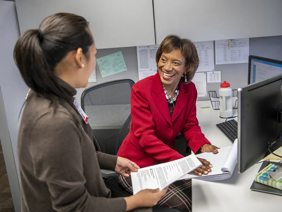 Two women talking at an office