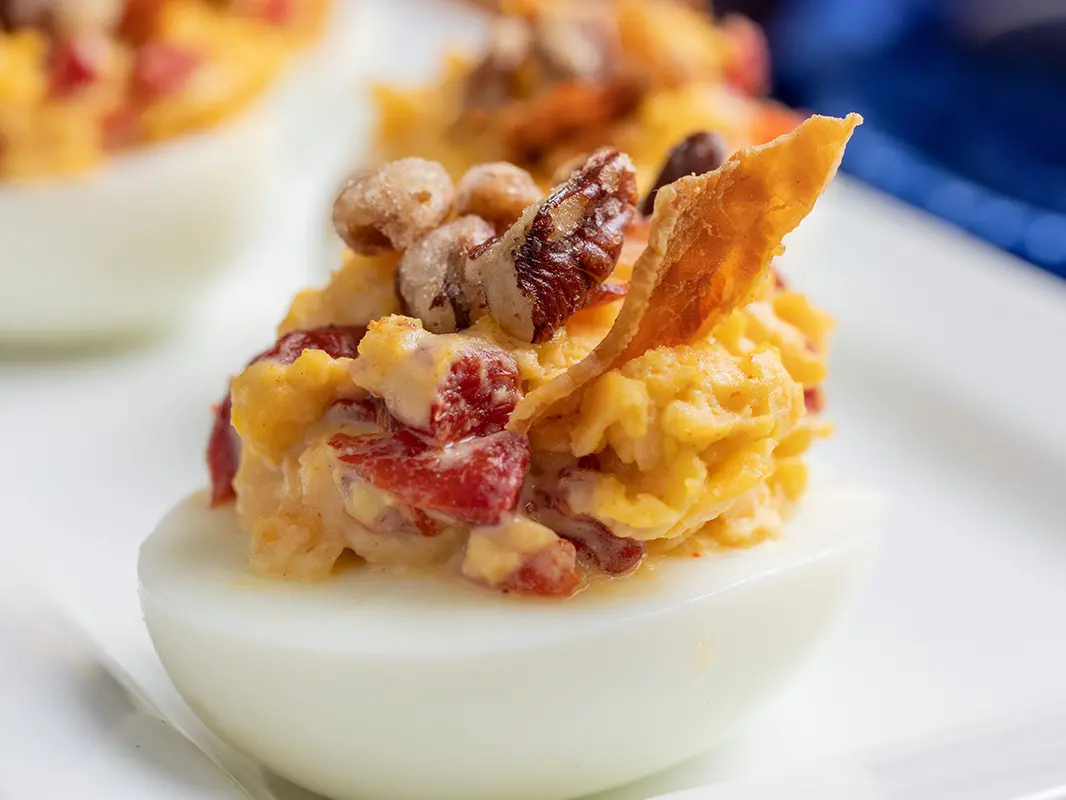 Deviled egg topped with bacon and pecans