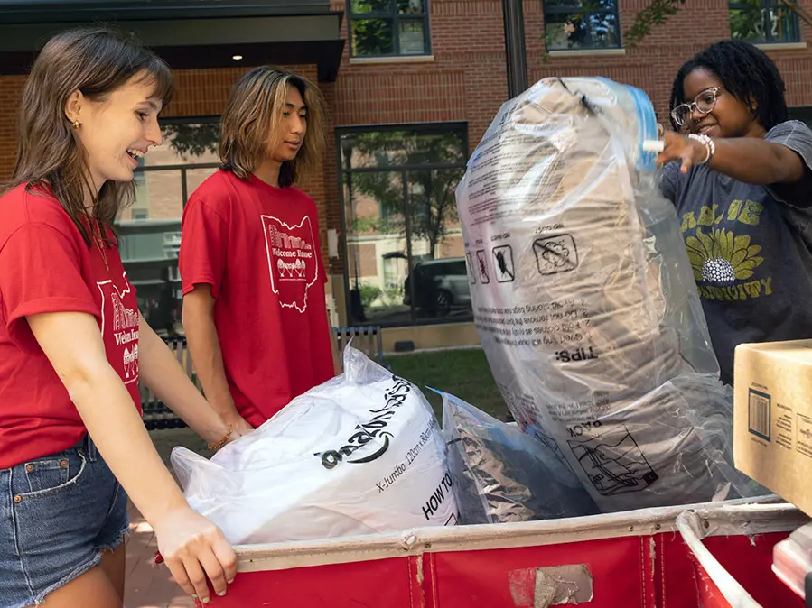 Several students move belongings into their residence hall