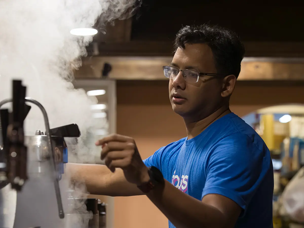Avishar Barua in his kitchen at the start of the day making coffee and surrounded by steam