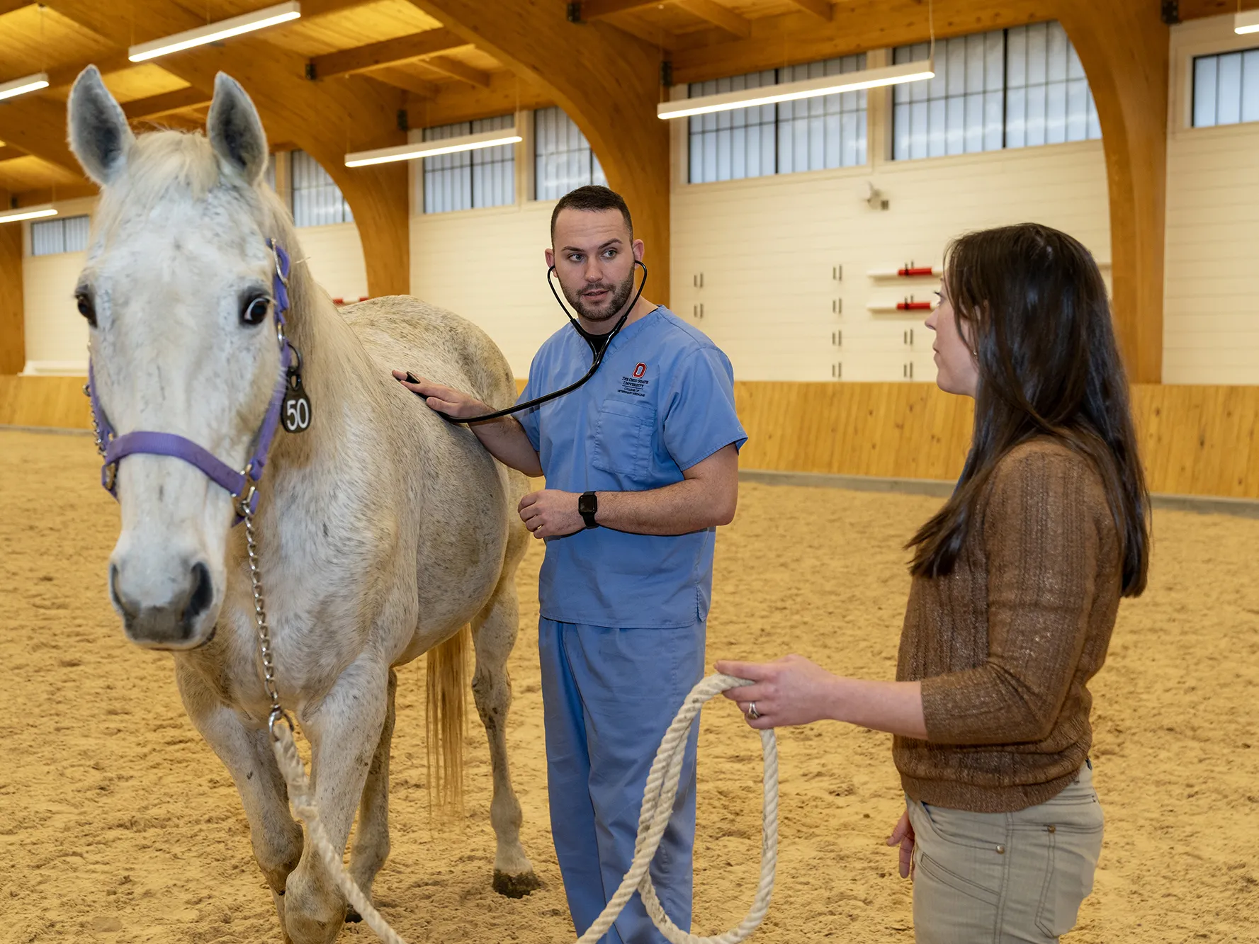 Veterinary Medicine student Shadow Montag holds a stethoscope to a horse’s side as he listens to his teacher explain a point.